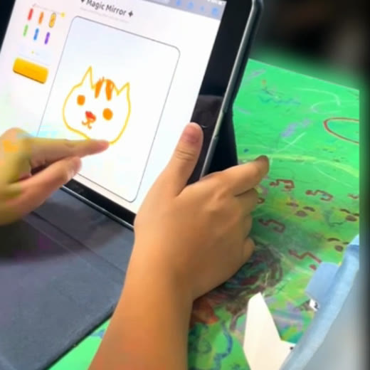 A child's simple orange cat drawn on the app canvas: two ears, two eyes, whiskers.